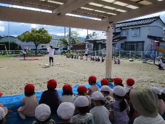 写真：運動会練習で、3歳児の玉入れ協議を応援する子どもたち。