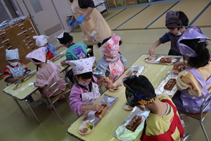 写真：ピザソースを塗った食パンに、ピザの具材を載せているぱんだ組3歳児