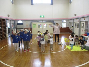 写真：子ども達が大きな口で歌いながら、両手を上に伸ばして左右に揺れています
