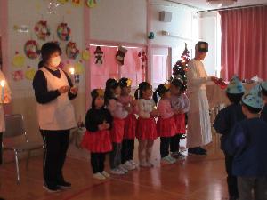 写真：年長児がキャンドルを持って、キャンドルサービスをおこなっているところ