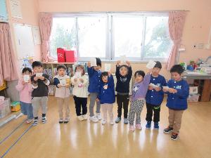 写真：お年玉探しゲームでお年玉を見つけた子どもたちが、お年玉を見せて喜んでいるところです。