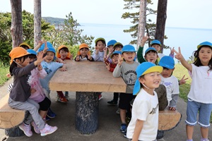 写真：子ども達が御野立公園の東屋で休憩しているところ。後ろには日本海が見えます