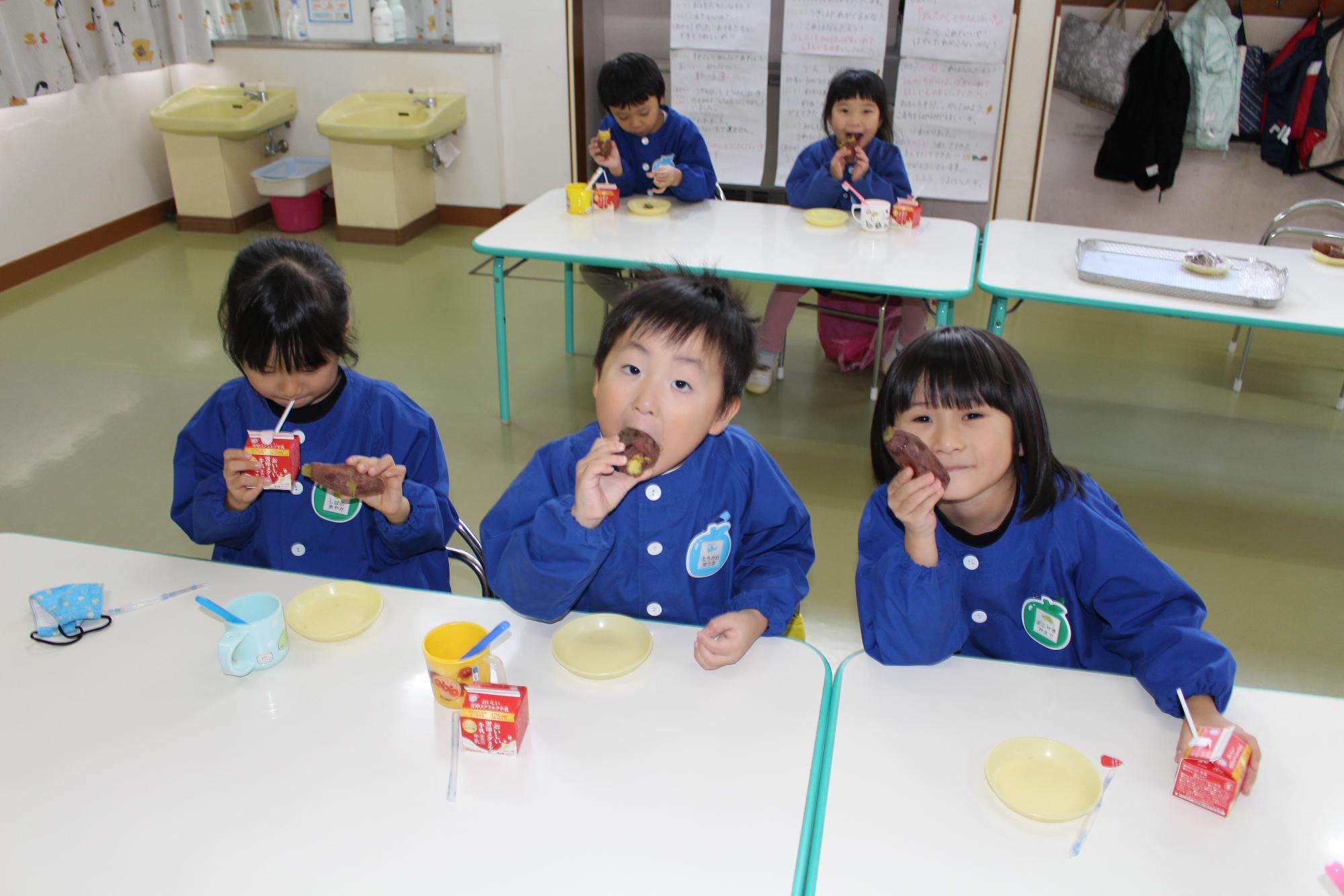 焼き芋を口いっぱいに頬張ったり、見たりしている写真。