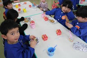 写真：焼きあがった手作りクッキーを見て、笑顔になるうさぎ組の子どもたち。隣の子どもと見せ合いっこをしている子もいます