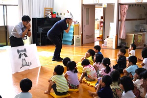 写真：講師の真似をして、口を両手で覆ってアライグマのポーズを取る子どもたち