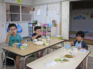 写真：自分達で作ったカレーをおいしそうに食べる子どもたち