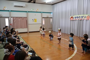 写真：りす組の子ども達が踊っているところ。目の前にいるおじいちゃん・おばあちゃんに見てもらおうと頑張っています