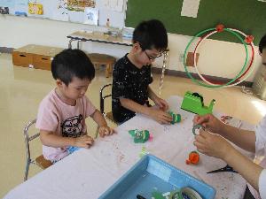 写真：風船で飛ぶカエルの制作を楽しむ子どもたち