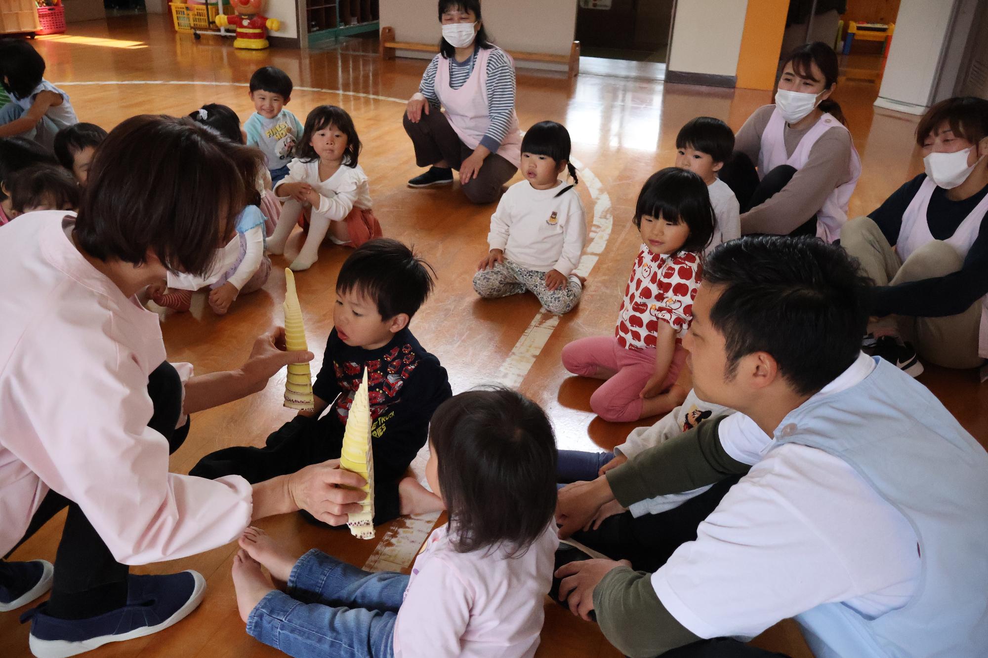 写真：皮をむいたたけのこの匂いを順番に嗅いでいる子どもたち