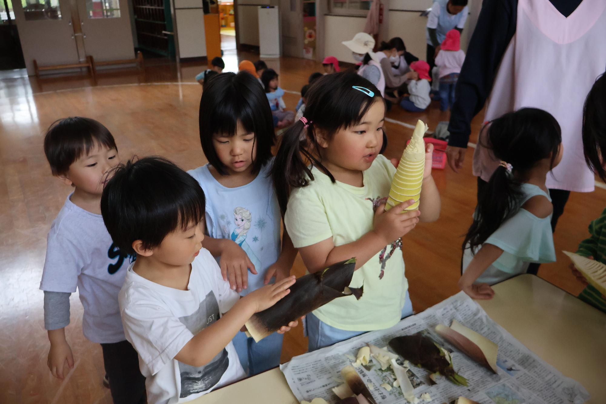 写真：たけのこの皮や実に触れる子どもたち