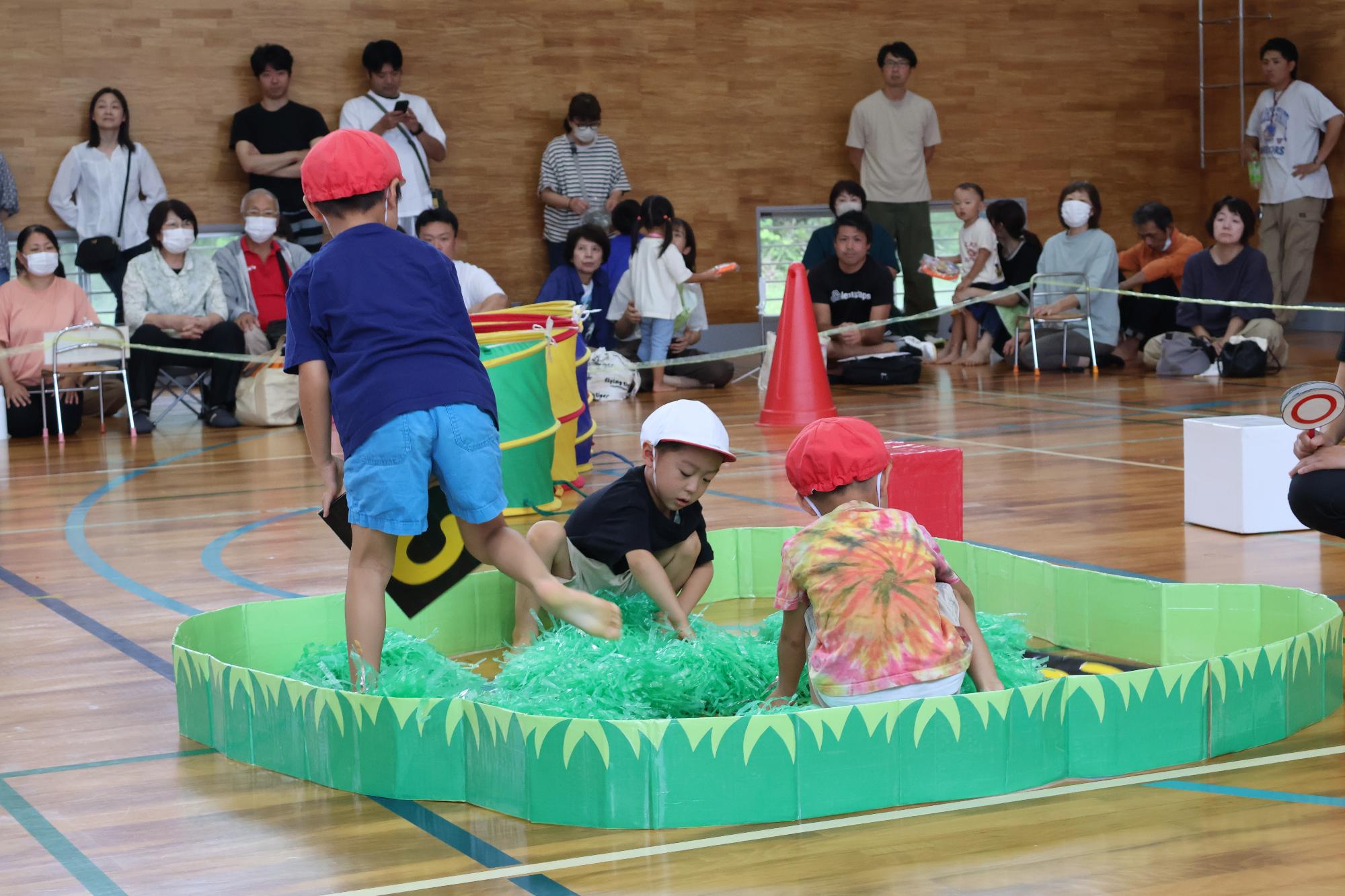 写真：障害物競争で隠れているカードを探している男の子たち