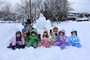 写真：子どもの背丈よりも大きい雪だるまと記念撮影をしたぱんだ組3歳児