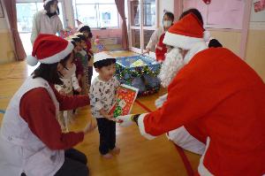 写真：サンタさんにクリスマスプレゼントをもらって喜ぶ園児