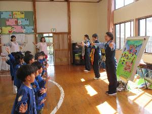交通指導員と園児が交通安全の体操を向かい合ってしている写真