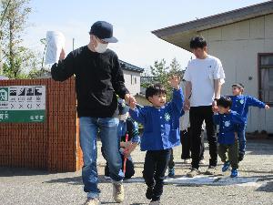 子どもと保護者が手をつないで道路を渡る練習をしている写真