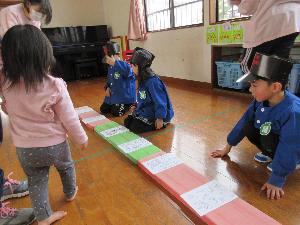 写真：積み木の上に並べられたはがきを、郵便屋さん役の年長児が販売しています。