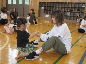 写真：園児とその保護者が向かい合い手をつないでいるところ