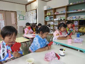 写真：3歳以上児の子どもたちが紫色に染め出された歯を手鏡で見ています