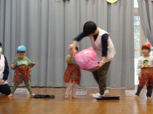 写真：未満児が発表会でこしみのを付けて劇ごっこをしています。