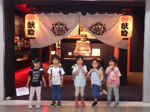 写真：子どもが博物館で展示されている閻魔様の前でポーズをとっている様子