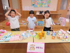 えんま市ごっこでおもちゃ屋さんの店番をするぞう組の子どもたち3人の写真