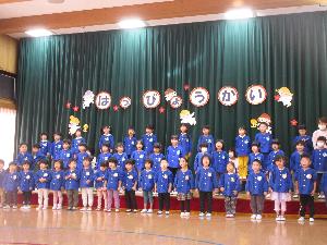写真：制服を着てステージに並び歌と手話ソングを披露する3・4・5歳児たち