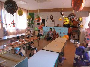 写真：ハロウィンの飾り付けをし、カーテンを閉めてお化け屋敷となった保育室で、仮装をして脅かそうとしている年長児