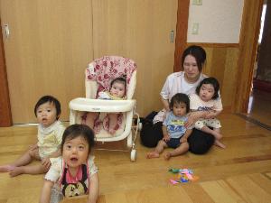 写真：虫探しで見つけた折り紙の虫とひよこ組の子ども達が写真を撮っているところ