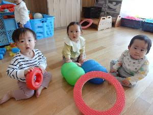 写真：ブロックやボールを手に持ち遊ぶ3人のひよこ組の子ども達たち