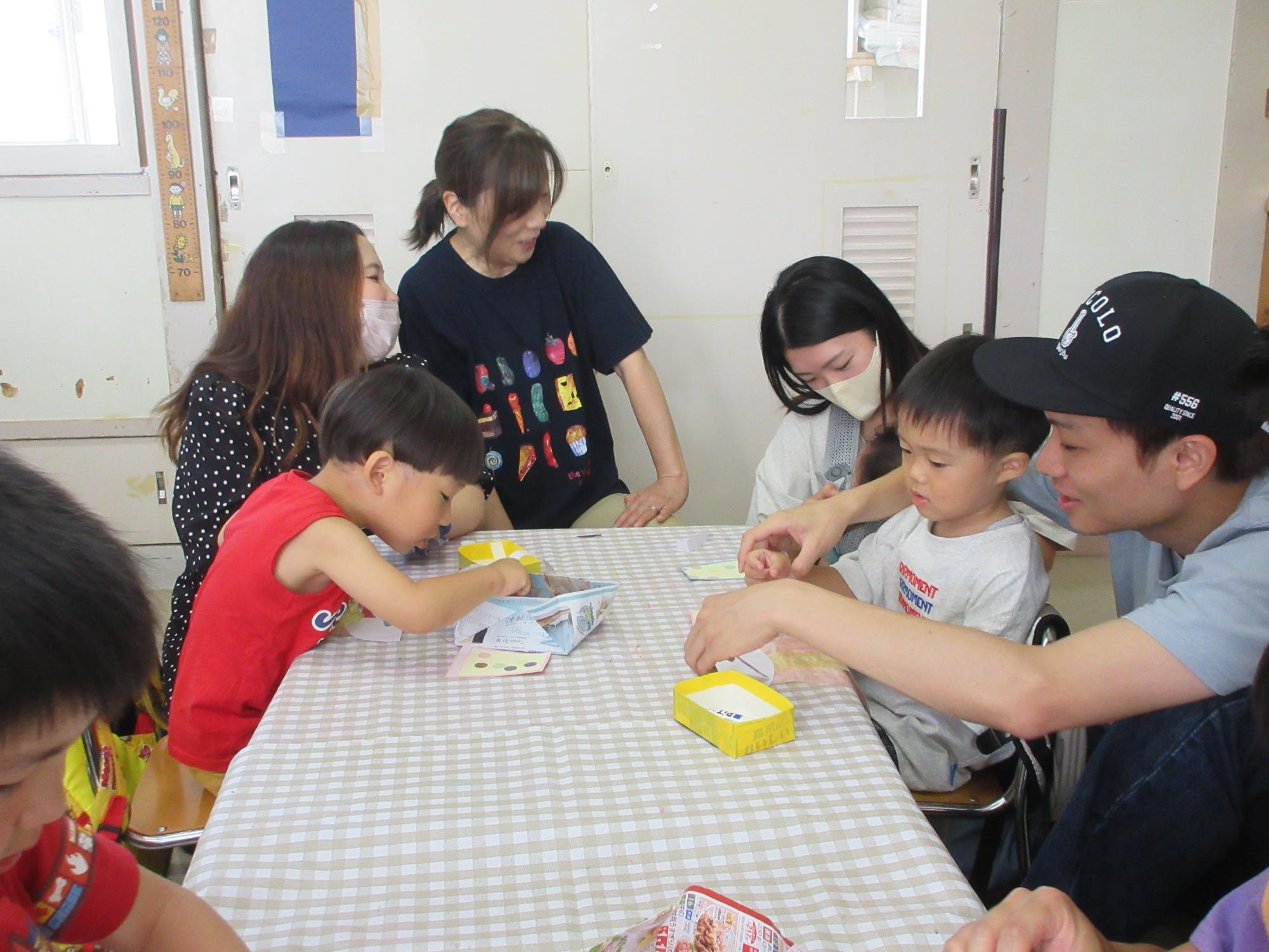 写真：2歳児がおうちの人と七夕の制作をしているところ