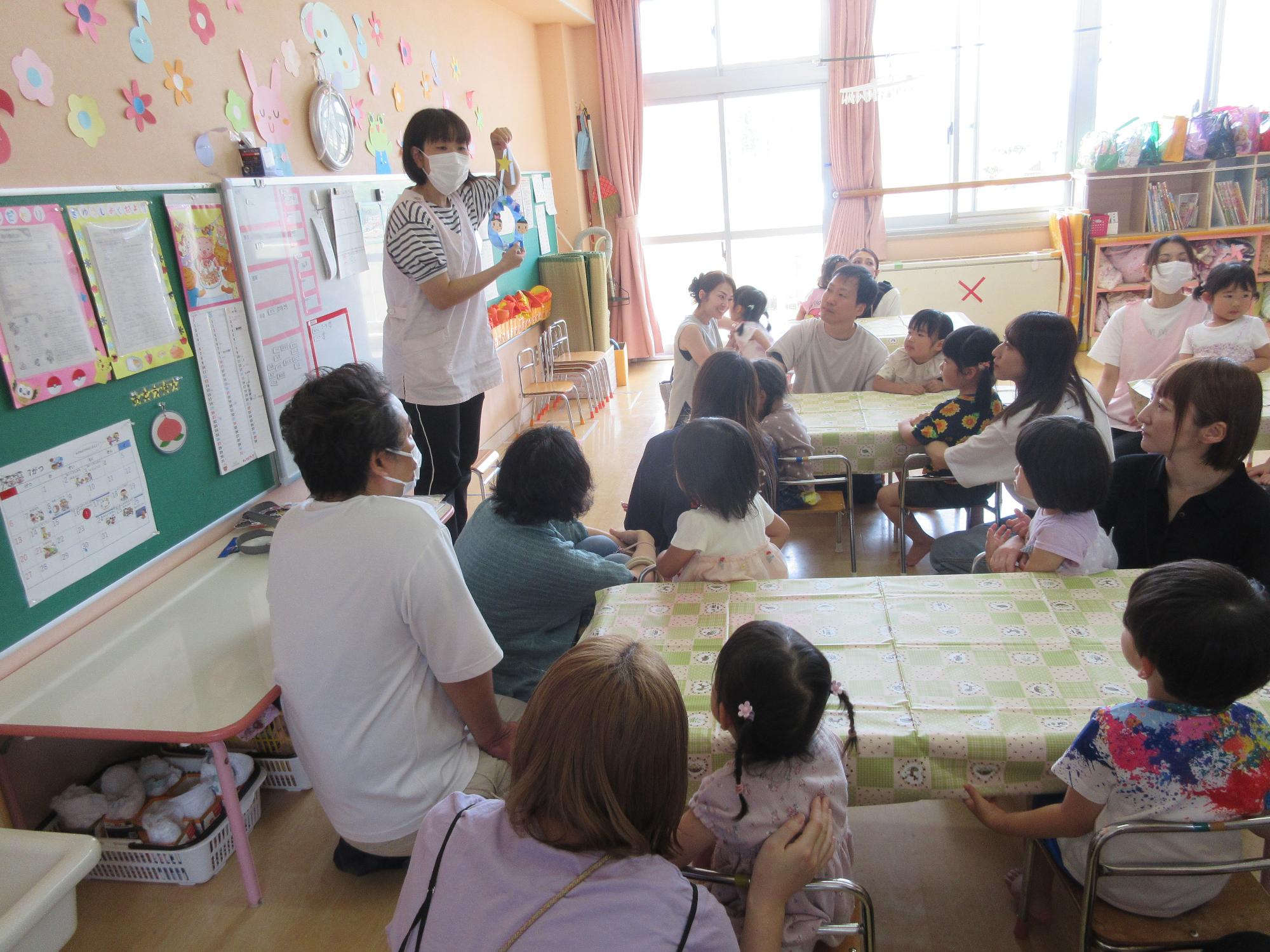 写真：おうちの人と制作の作り方を聞く3歳児の子どもたち