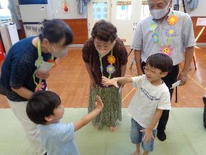 写真：園児がじゃんけんする様子を祖父母が見守っています。