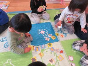写真：子ども達がカルタとりをして遊んでいるところ。取り札には動物の絵が描かれています