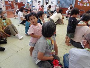 写真：園児がたちがおじいちゃんおばあちゃんの後ろに回って、優しく肩をたたいています