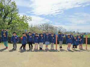 写真：鉄棒にぶら下がるきりん組12人の子どもたち