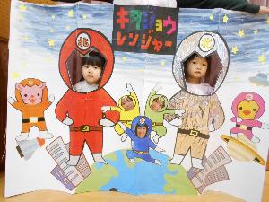 写真：北条レンジャーの絵が描いてある顔はめパネルから顔をのぞかせる1歳児と2歳児の2人