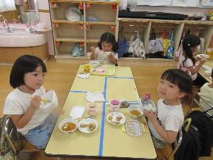 写真：お弁当箱を手に持ち給食を食べている子どもたち