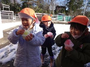 写真：雪をカップに入れかき氷に見立てて食べる真似をしているところ