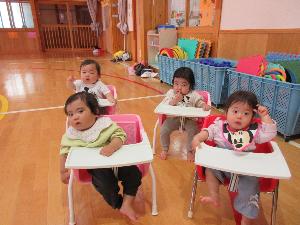写真：遊戯室での集会にひよこ組の子どもたちが椅子に座りお話を聞いています