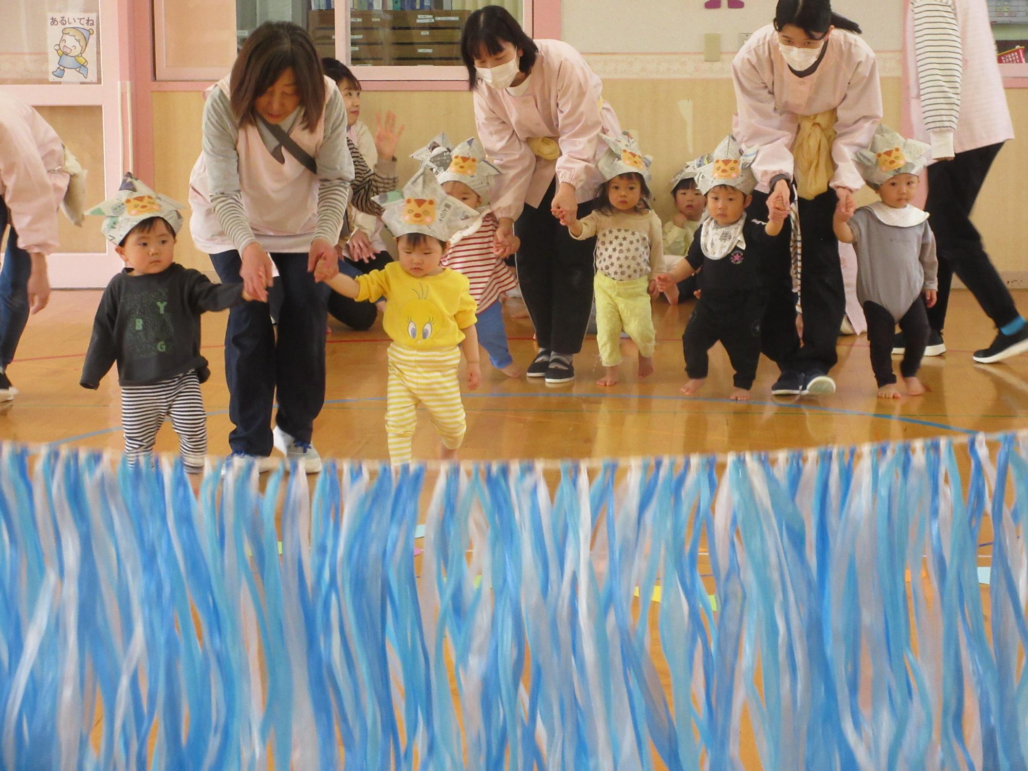 写真：りす組の子ども達がかぶとをかぶってゲームに参加している。手前には天の川に見立てたたくさんのスズランテープが揺れています