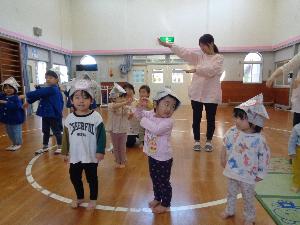 写真：こいのぼりの歌を踊りながら歌うぱんだ組の子どもたち。両手を体の横でひらひらさせ、こいのぼりの尾ひれを真似しています