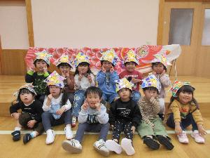 写真：紙で折った兜をかぶった3歳児のきりん組がこいのぼりの前に並んでいます