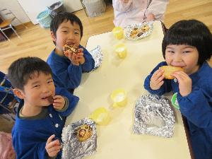 3人の子どもが、自分で作ったクッキーを嬉しそうに食べている写真