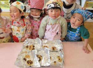 写真：うさぎ組の子ども達が自分で作ったクッキーと一緒に記念写真を撮っているところ