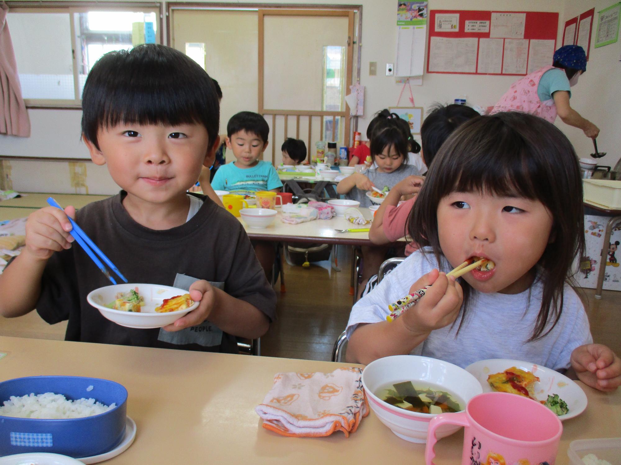 写真：保育園で育てた野菜が入っている給食をおいしくいただいています。