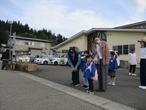 写真：保育園の敷地から道路に出る前に、子どもと保護者が左右を確認している様子