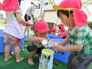 りす組の子ども達が空きカップを使って水遊びをしています。