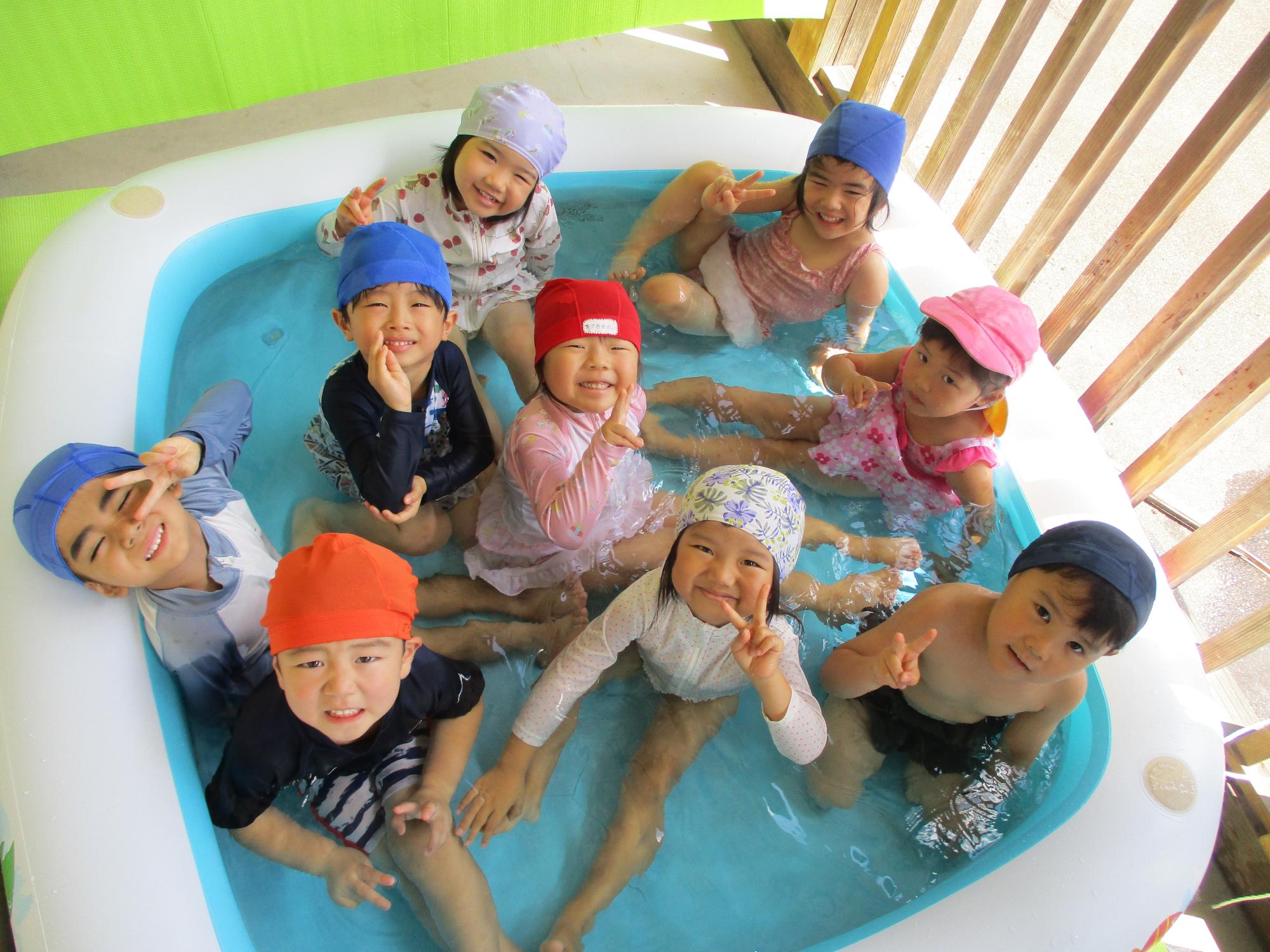 写真：3歳児9人がビニールプールの中で遊んでいます
