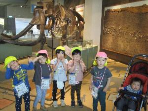 博物館のナウマンゾウの骨の展示の前で記念撮影をする7人の子ども達