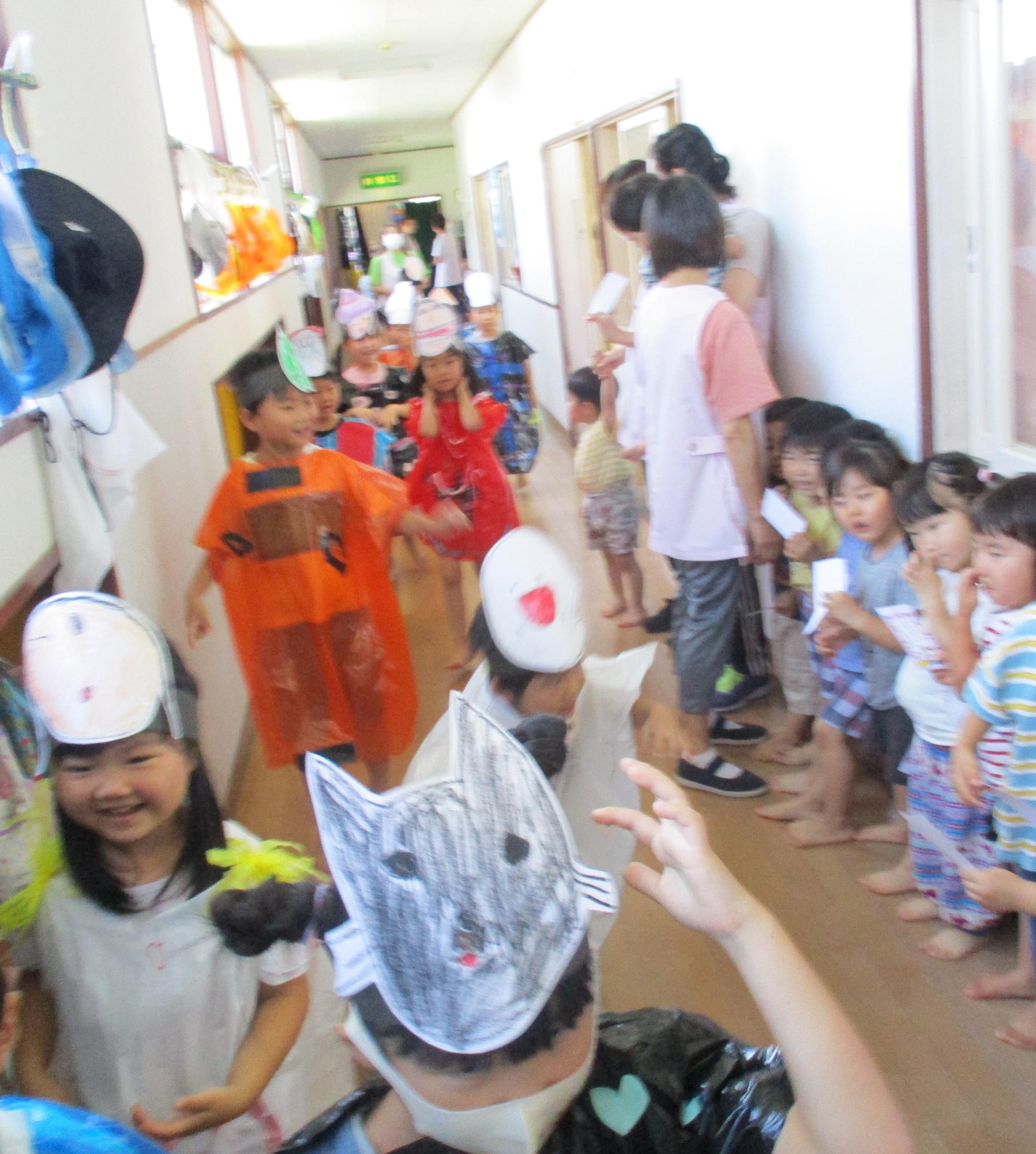 写真：きりん組の子どもたちがおばけの仮装をして、クラス前の廊下を列になって歩いています。